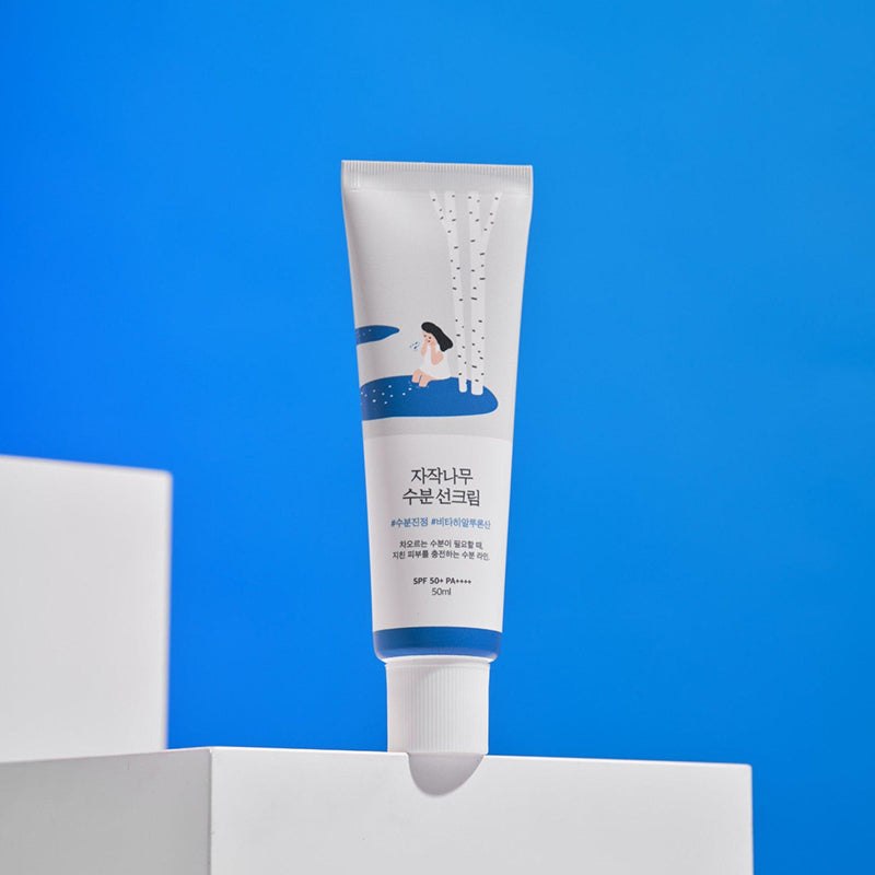 Round Lab Birch Juice Moisturizing Sun Cream SPF50+ 50ml - tube on blue podium - Korean skincare from 2M Beauty